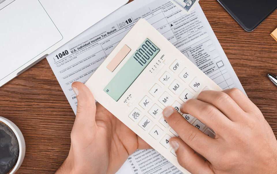 A person using a calculator to calculate their R&D Tax Credit